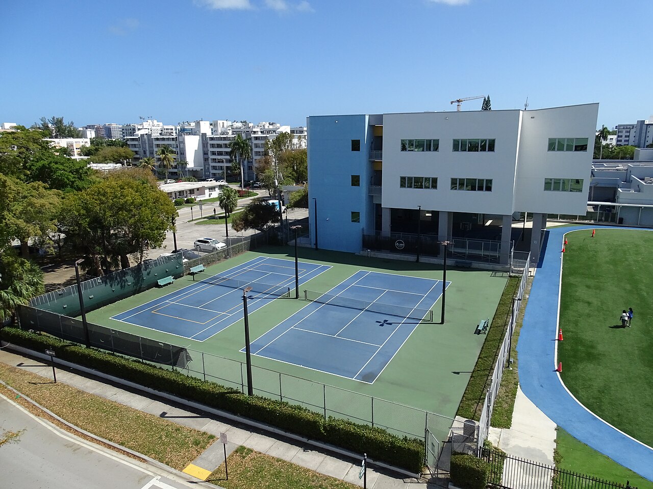 城市建筑旁的蓝色公共网球场俯视图